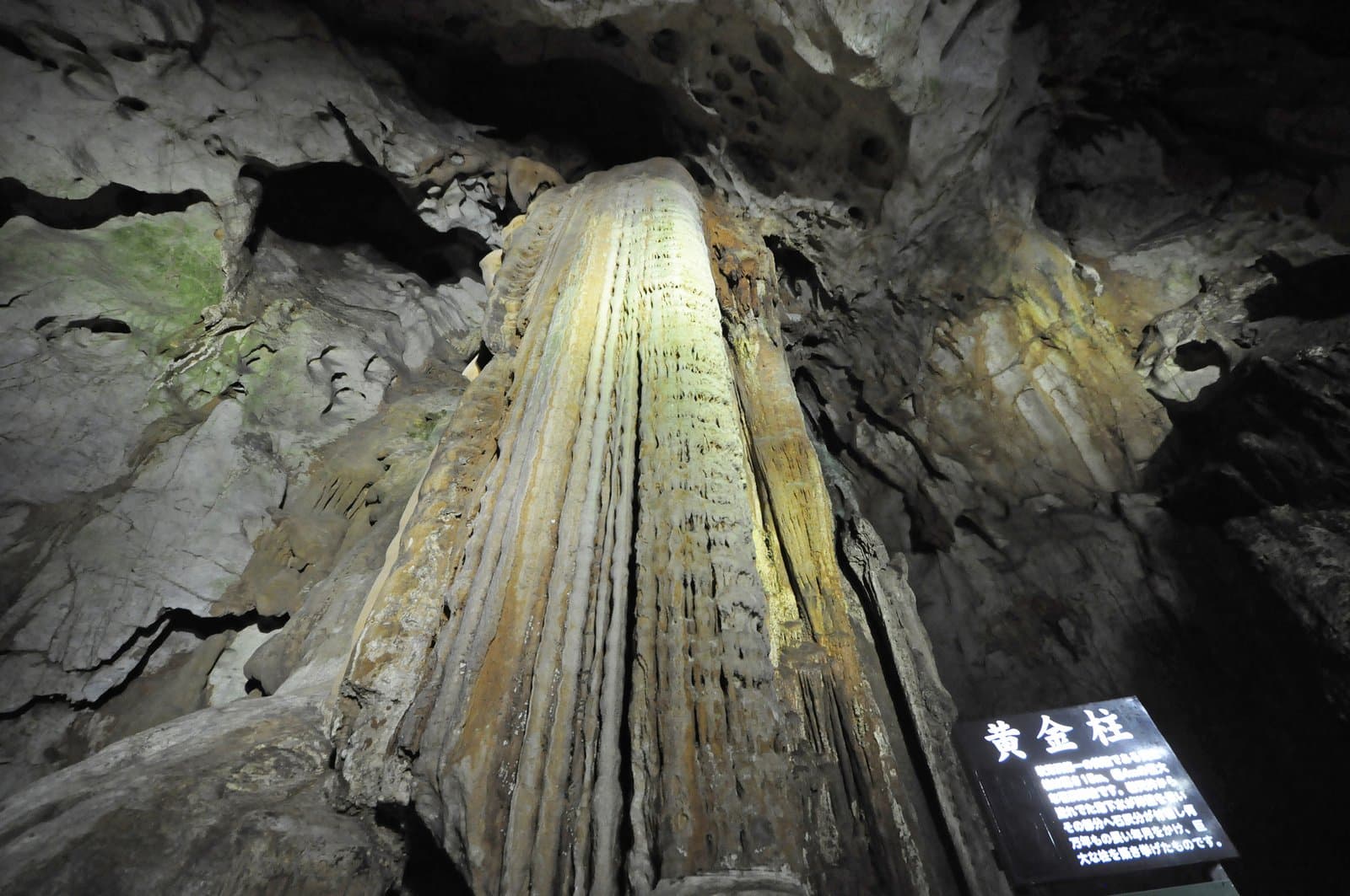 A tall pillar of golden flowstone inside a cave