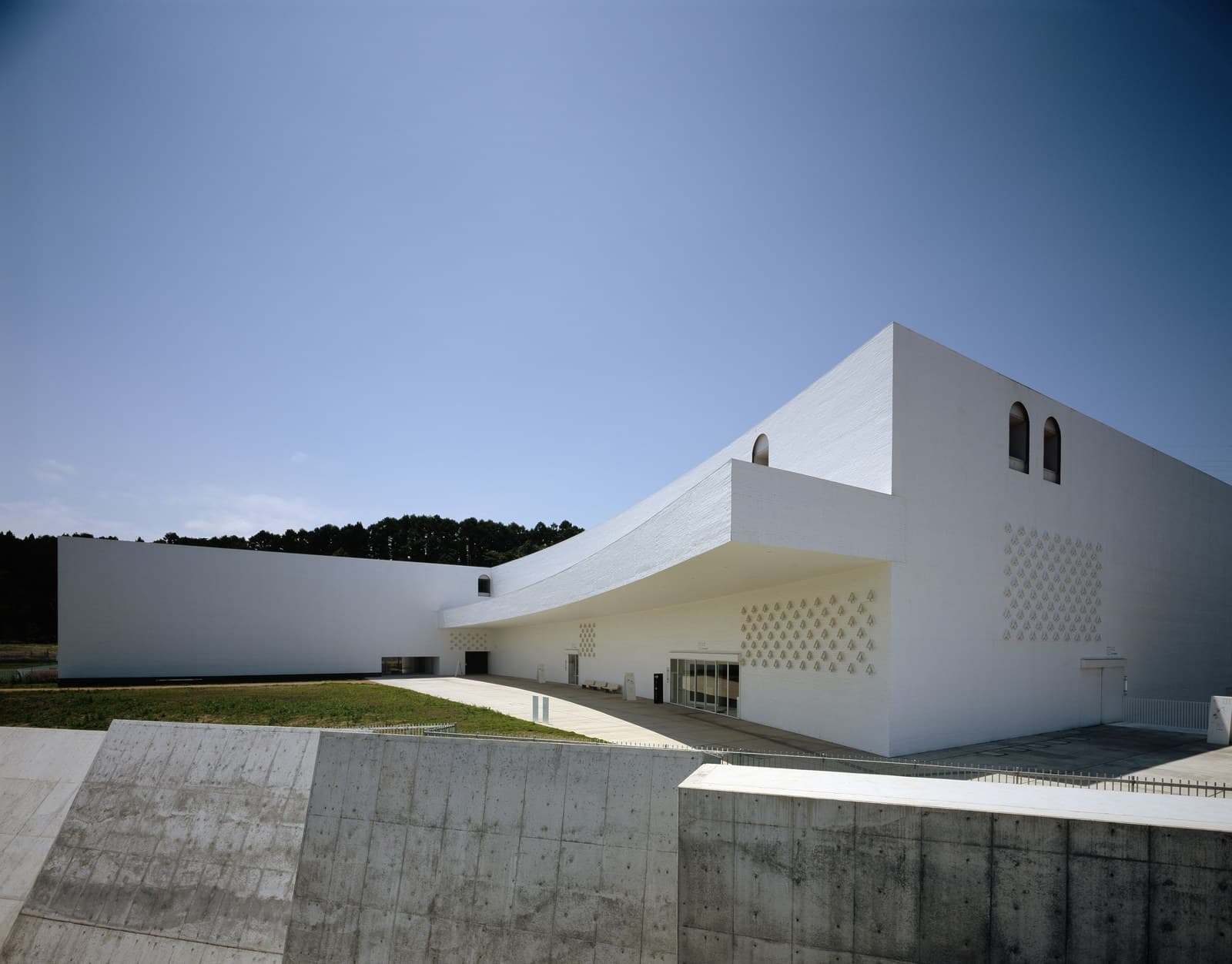 The white, angular museum building under a blue sky