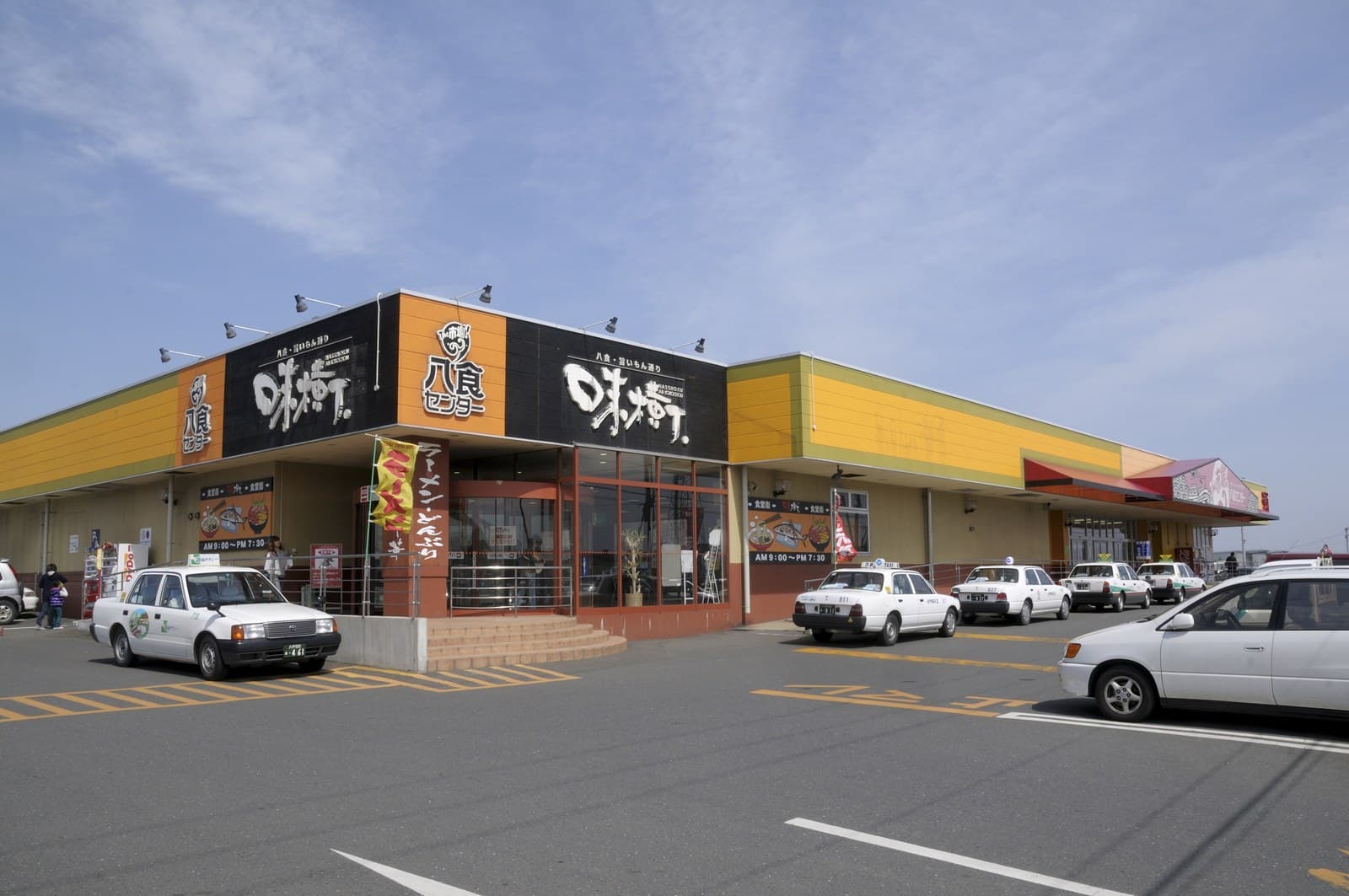 The front of the market building with its signs and taxis waiting outside