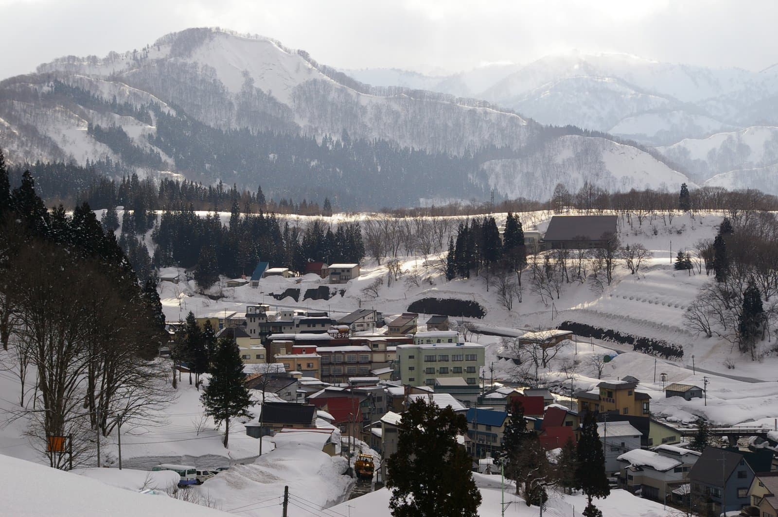 The snow-covered hot-spring village of Hijiori in a valley below snowy mountains