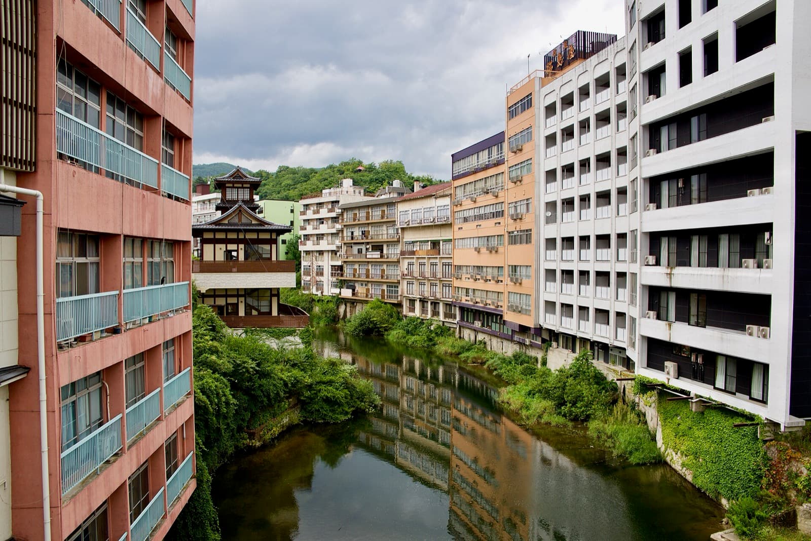 Hotels and inns lining both banks of a river in a hot-spring town