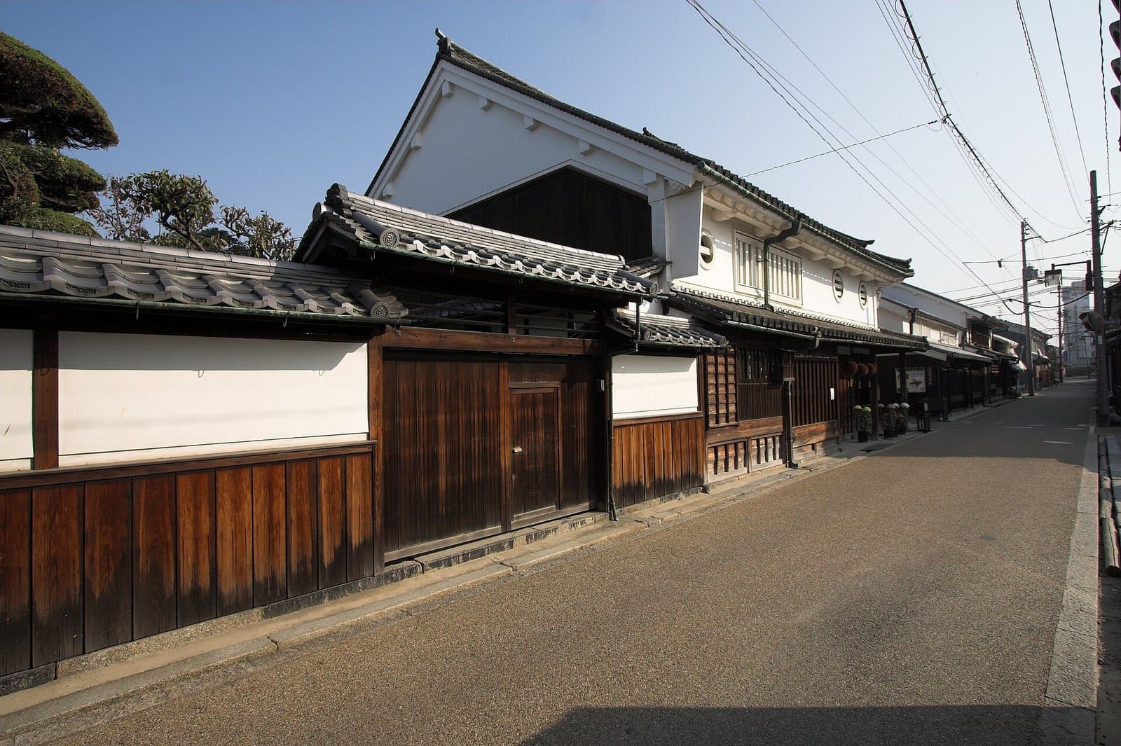 白壁と黒い板張りの伝統的な町家が並ぶ静かな通り