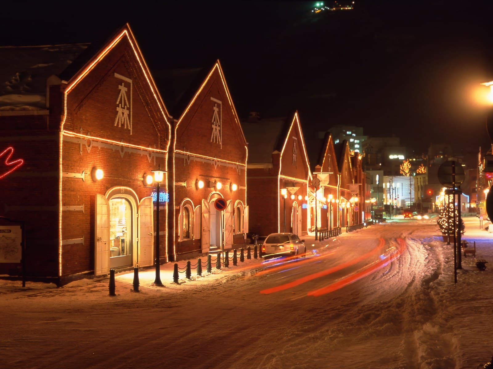 Red-brick warehouses outlined in lights on a snowy winter night
