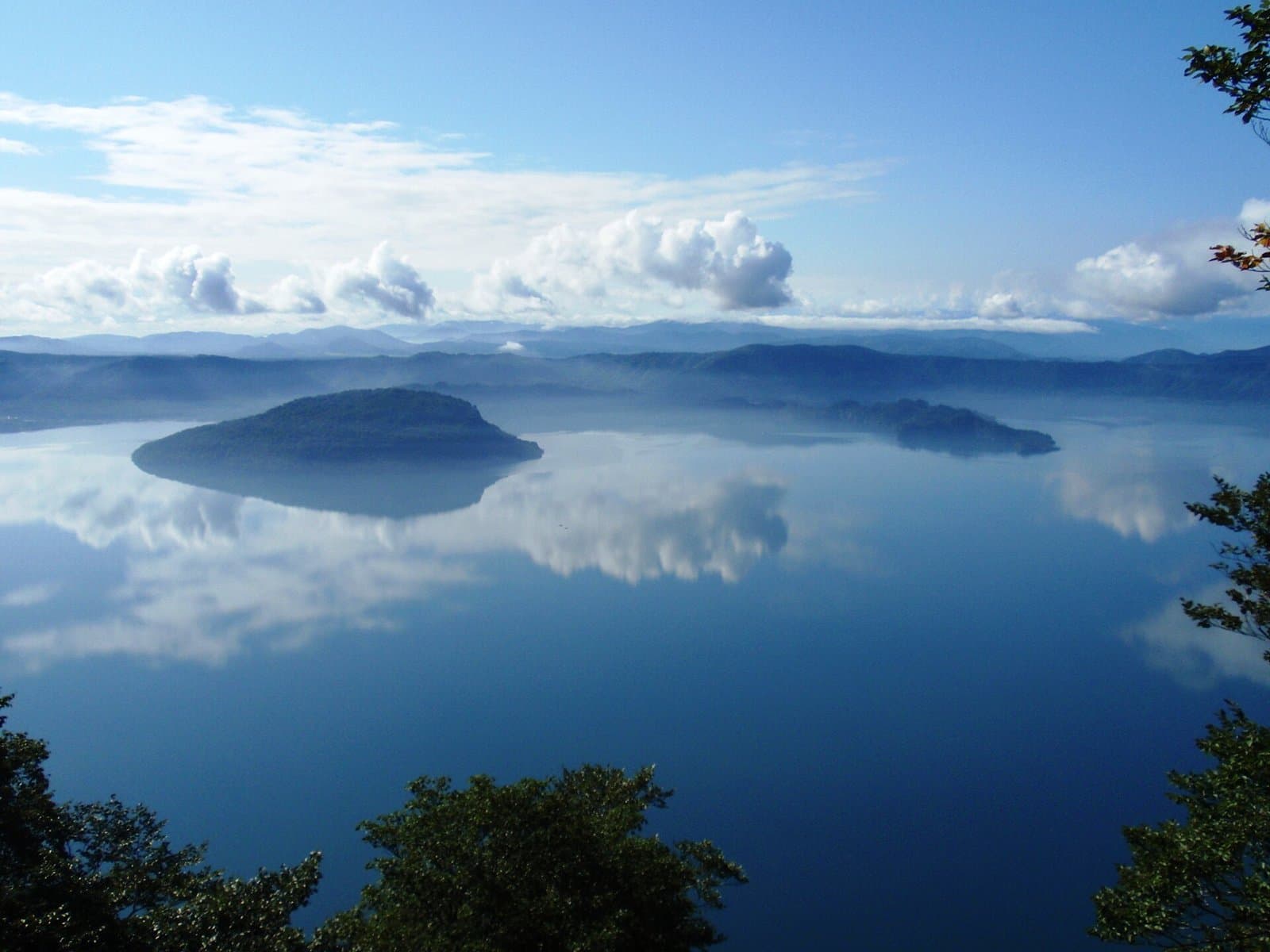 Lake Towada with a peninsula reflecting clouds, seen from a mountain