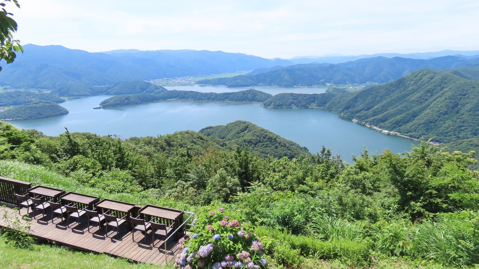Lakes surrounded by green mountains, seen from a summit deck