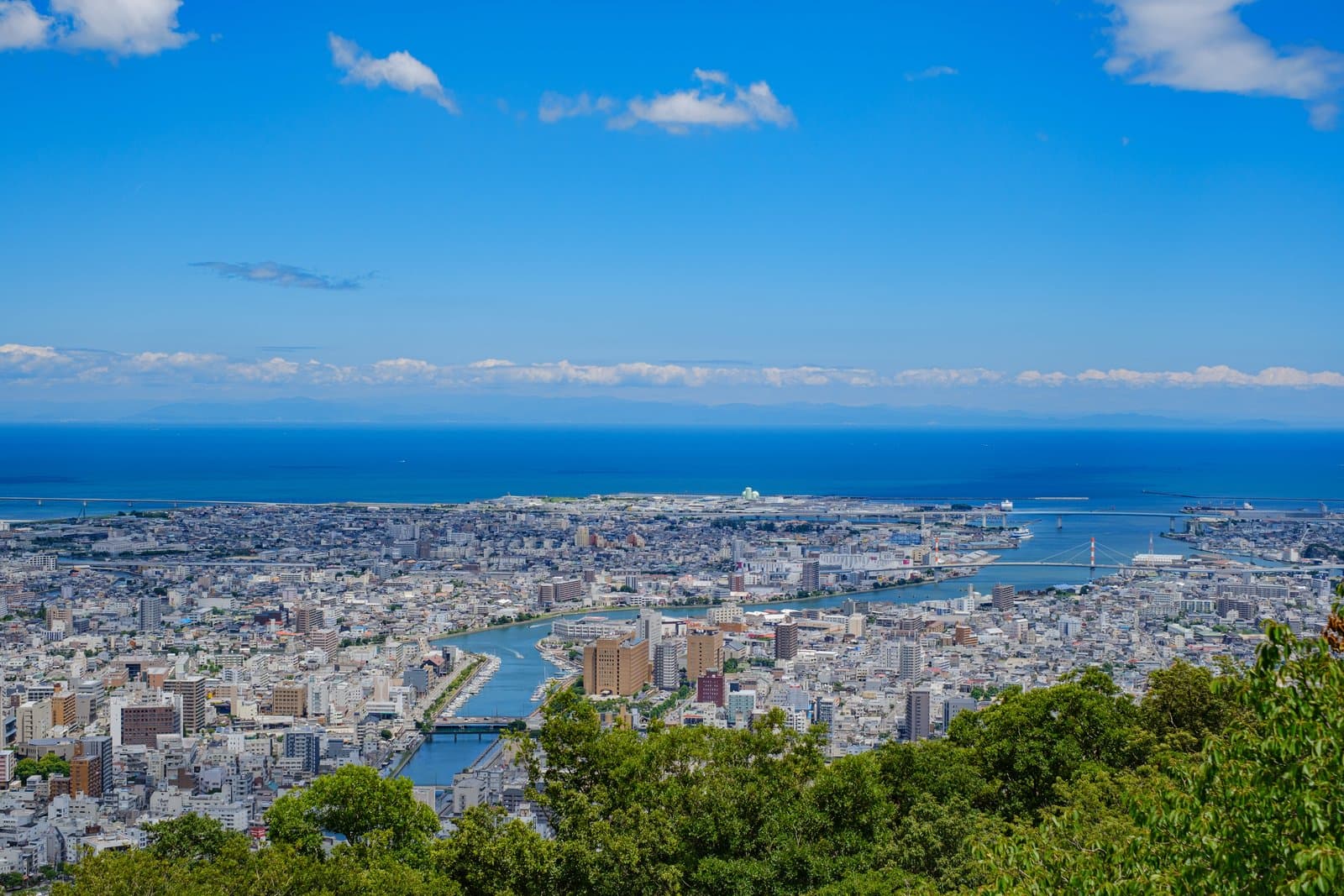 A view from a mountaintop over the city of Tokushima to the sea