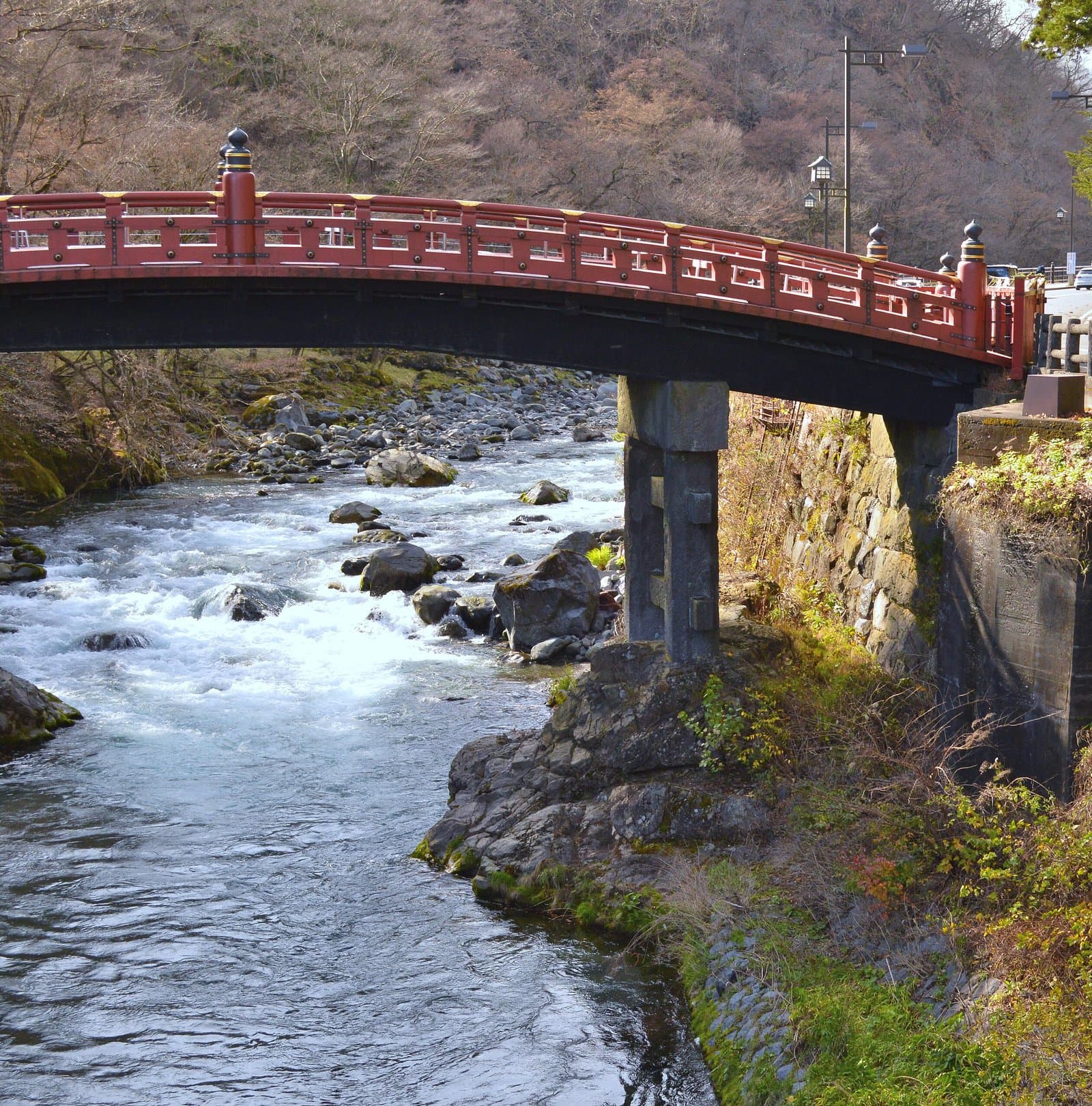 岩の多い川にかかる朱塗りの木造の神橋