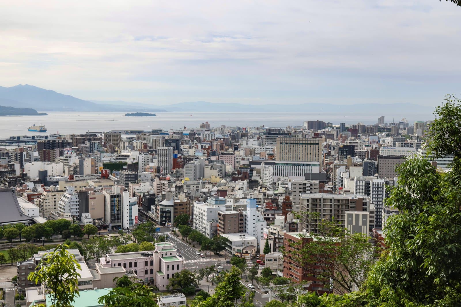 A view over the city of Kagoshima to Kinko Bay under a pale sky