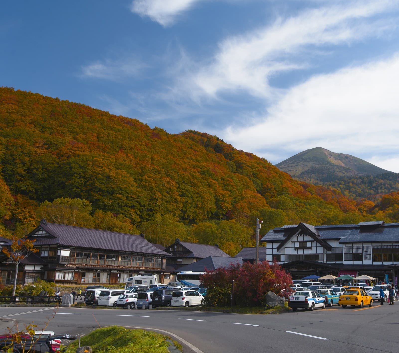 The old wooden inn buildings below autumn-coloured mountains