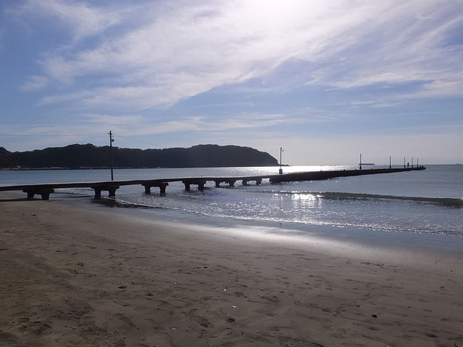 砂浜からきらめく海へ長く延びる桟橋