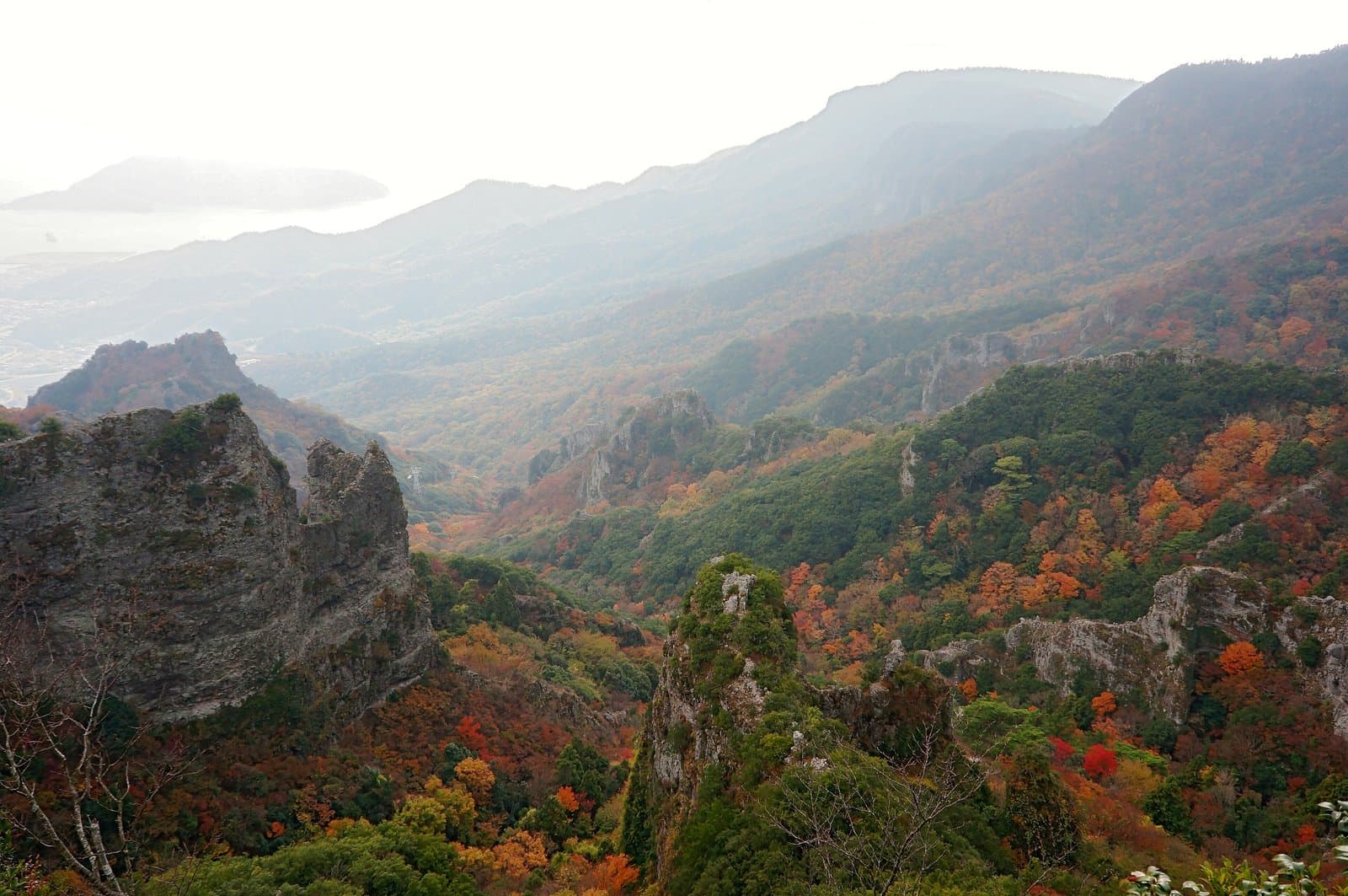 紅葉に色づいた谷とぎざぎざの岩峰
